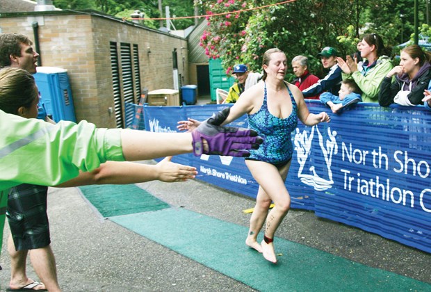 Coquitlam RCMP Cst. Annelise Lovell gets high fives from her relay teammates during the new Police, Fire and Rescue Challenge portion of the North Shore Triathlon Monday.