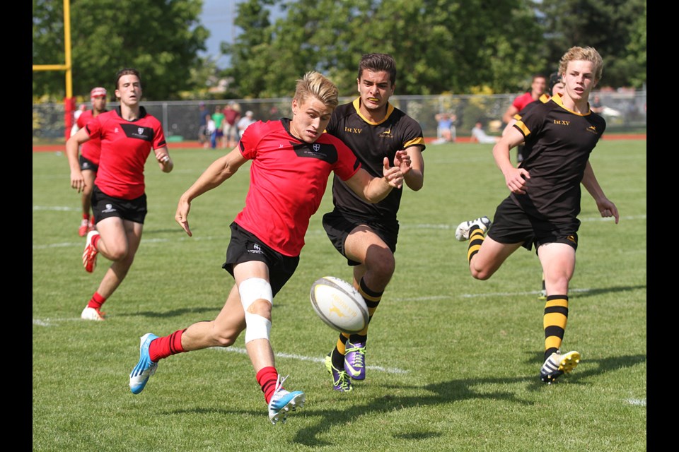 Phil Berna drop kicks the ball on the fly in a St. George's come-from-behind win in the senior boys rugby championship against Shawnigan Lake at Abbotsford Exhibition Park on May 31, 2014. The Saints won 15-12.