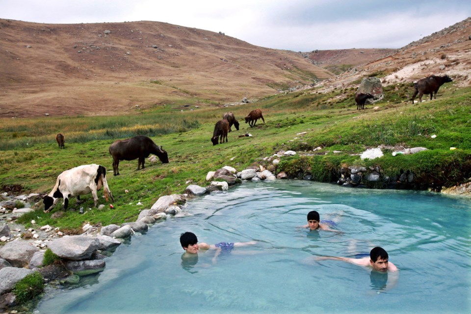 In this Sept. 13, 2013 photo, Iranians bathe at a hot mineral water spring on the slopes of Iran's Sabalan mountain, near the northwestern town of Sarein.