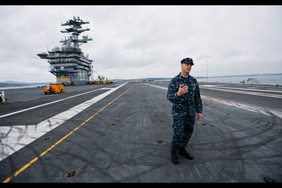 Saturday: Captain J.J. Cummings explains flight operations on the flight deck of the USS Nimitz.