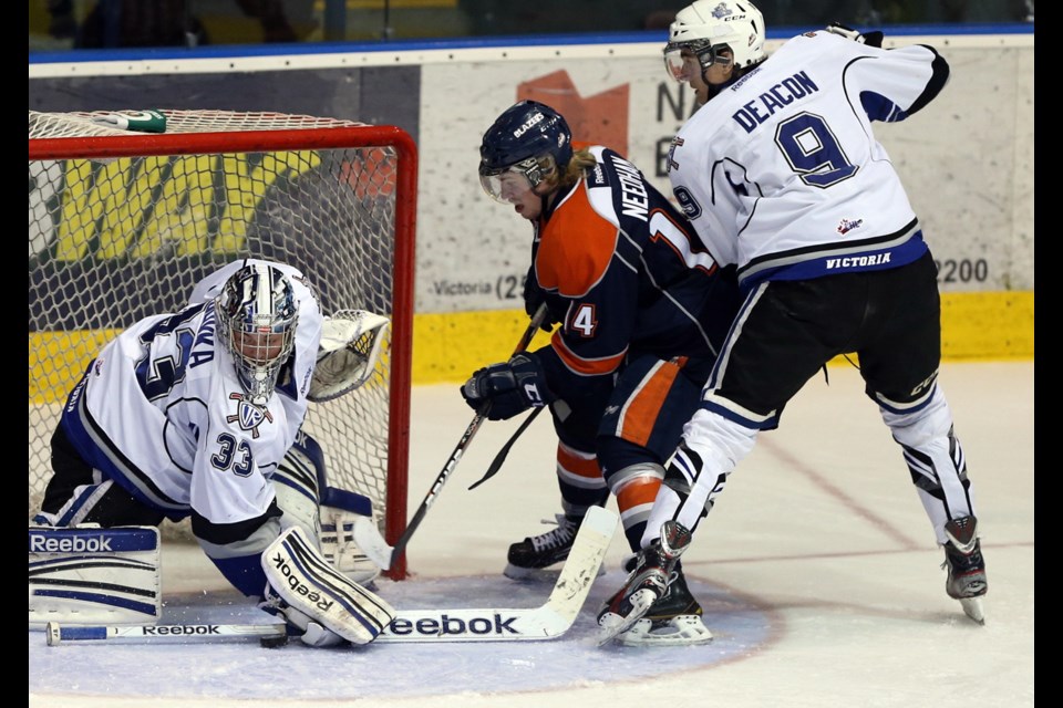 Royals goalie #33 Patrik Polivka makes a save on Blazers #14 Matt Needham and is checked by #9 Mitch Deacon in 2nd period action in Game 3 of WHL first-round playoff series between Victoria Royals and Kamloops Blazers at Bear Mountain Arena.