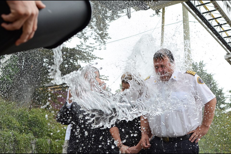 (Left to right) Honour House general manager Craig Longstaff, president Al De Genova, BC Paramedic Union president Bronwyn Barter and New West fire chief Tim Armstrong get splashed taking the ALS Ice Bucket Challenge in front of Honour House Friday.