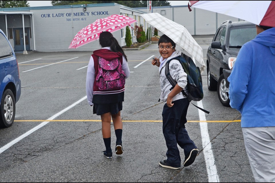 Students head in to Our Lady of Mercy Elementary School in Burnaby for the first day of school Tuesday.