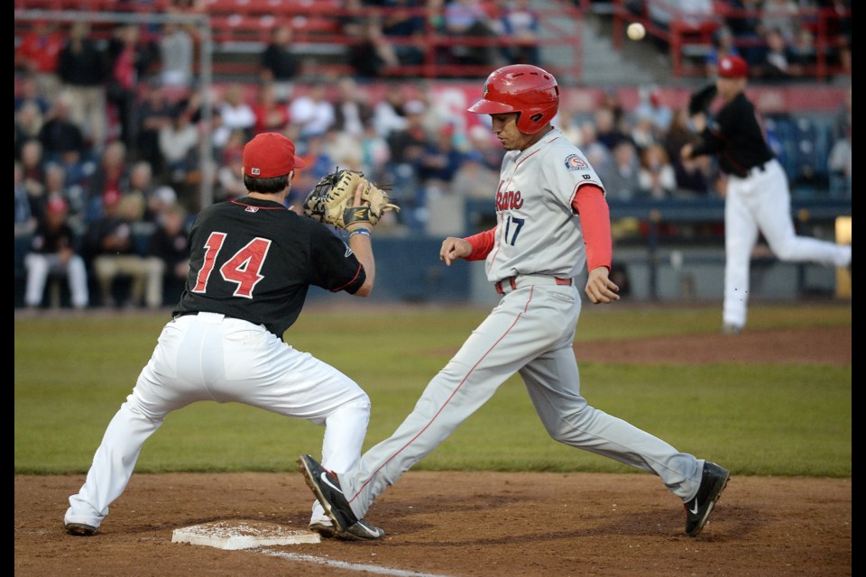 Ryan McBroom (No. 14 in black) draws the runner back to first base with a throw from pitcher Ryan Borucki in a 1-0 win over Spokane in Game 1 of the North Division pennant at Nat Bailey Stadium on Sept. 3, 2014.