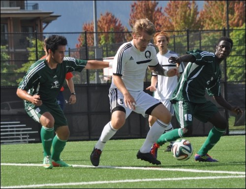 Quest's Max Tagesen battles for the ball with Royals defenders during Pacwest soccer action on Sunday (Sept. 14).