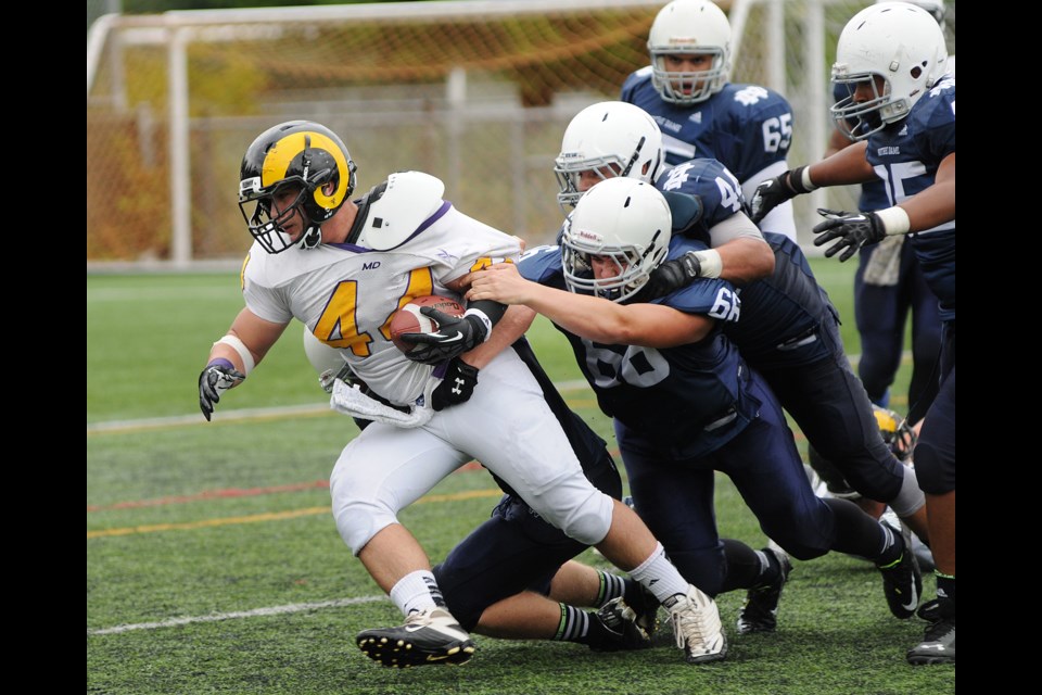 Five Notre Dame Jugglers, including Luca Rizzo (No. 66) and Matteo Triggiano (No. 44), pile on the ball-carrier during a 36-7 loss to the Mt. Douglas Rams on Sept. 19, 2014. Photo Dan Toulgoet