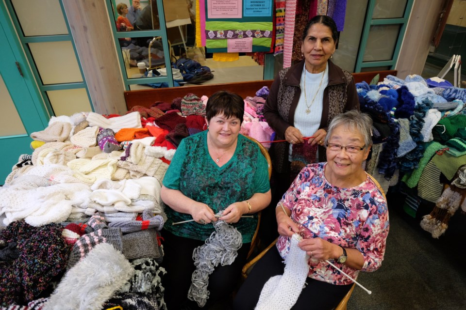 Confederation Seniors Centre volunteers have been hard at work knitting a lot of scarves, toques and mittens to be donated to people in need. Phyllis Grippo, Daljit Birk and May Quan are part of the group.