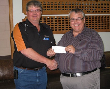 Darren Grimes accepts a donation of $2,000 towards the elevator installation at Memorial Hall in Carlyle. He is accepting the cheque from Keith Walker.