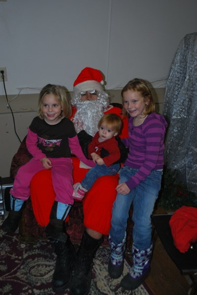 Taking advantage of an available knee, Darcie (left) Alix and Taris Rae (right) spend some time with Santa Claus at the annual Breakfast with Santa, held in Memorial Hall on the morning of Saturday, Dec. 4.