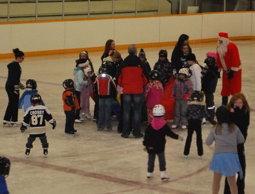 Santa takes a skate over to all of the young skaters to help out with the parachute game after handing out all of the goodies to the children.