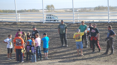 Local Joey Galloway draws his number for the feature race while Steve Arpin (surrounded by kids) looks on.