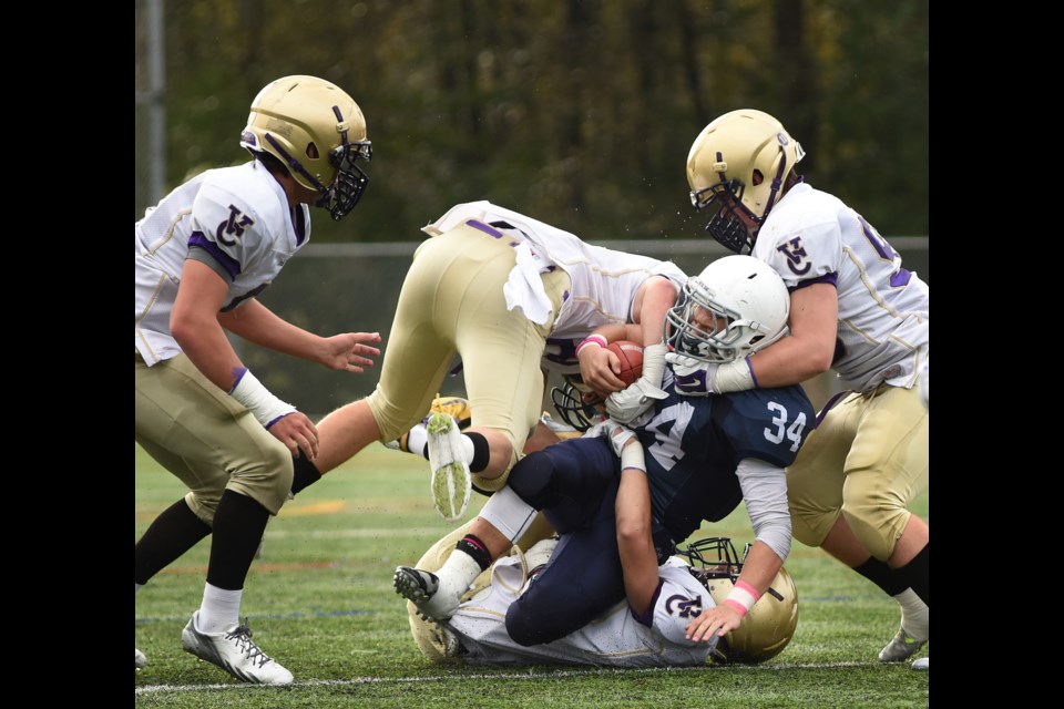 Notre Dame running back Nicholas Carusi (No. 34) is hauled down by three 鶹ýӳCollege tacklers in a 46-7 鶹ýӳCollege win at Burnaby Lake Park on Oct. 31. Photo Dan Toulgoet