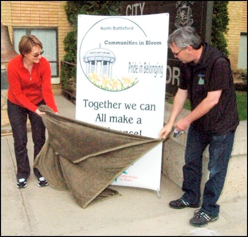 The North Batttleford Communities In Bloom Committee held its kickoff ceremonies at the end of May. North Battleford Mayor Ian Hamilton and Communities in Bloom North Battleford chair Charlotte Hamilton unveil the committee&#8217;s banner.