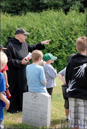 Father Demetrius Wasylyniuk, OSB, points out an interesting grave to the children of the City of Humboldt&#8217;s Kids Summer Fun Program during a field trip to St. Peter&#8217;s Abbey and College on July 8.