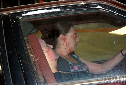 The driver who caused the mock collision (background) tries to deal with what has happened before the emergency services arrive, while her friend sits unconscious beside her in the vehicle.