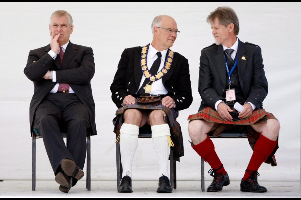 Prince Andrew, the Duke of York and honorary chief of the 150th Victoria Highland Games and Celtic Festival, left, Victoria Mayor Dean Fortin, centre, and Jim Maxwell, president of the Highland Games Association, await the start of the mass pipe and drum performance on Sunday at Topaz Park.