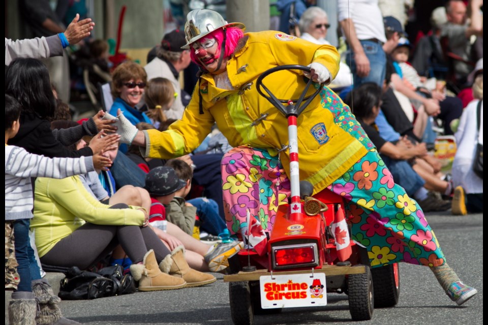 Pumper the clown gets high fives in the Island Farms Victoria Day Parade.