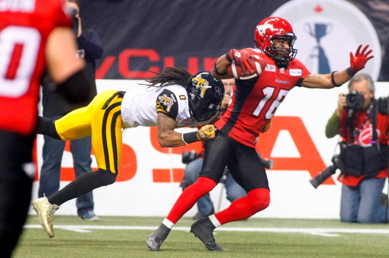 Calgary Stampeder Marquay McDaniel is tackled by Hamilton Tiger-Cat Rico Murray during the first half of the 102nd Grey Cup at B.C. Place Nov. 30, 2014. Photo Geoff Howe / CFL