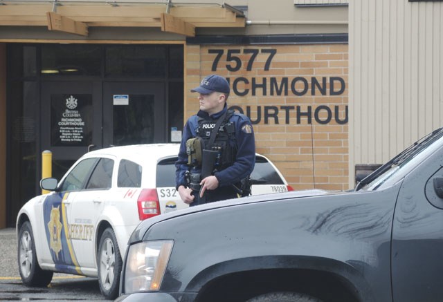 A Mountie armed with an assault rifle guards Richmond Provincial Courthouse Thursday morning