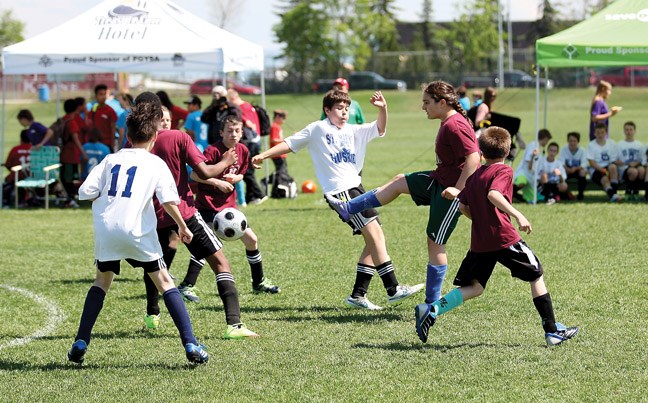 It's a battle for the ball when the St. Mary's Huskies Team No. 1 (white) takes on the I C Kodiaks Team No. 2 (red) Friday afternoon during the Terry Wilson Memorial Soccer Tournament at Rotary Fields.