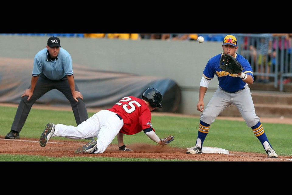 Victoria HarbourCats' Chase Lambert beats the pickoff attempt by Kitsap BlueJackets' Jake Scudder, right.