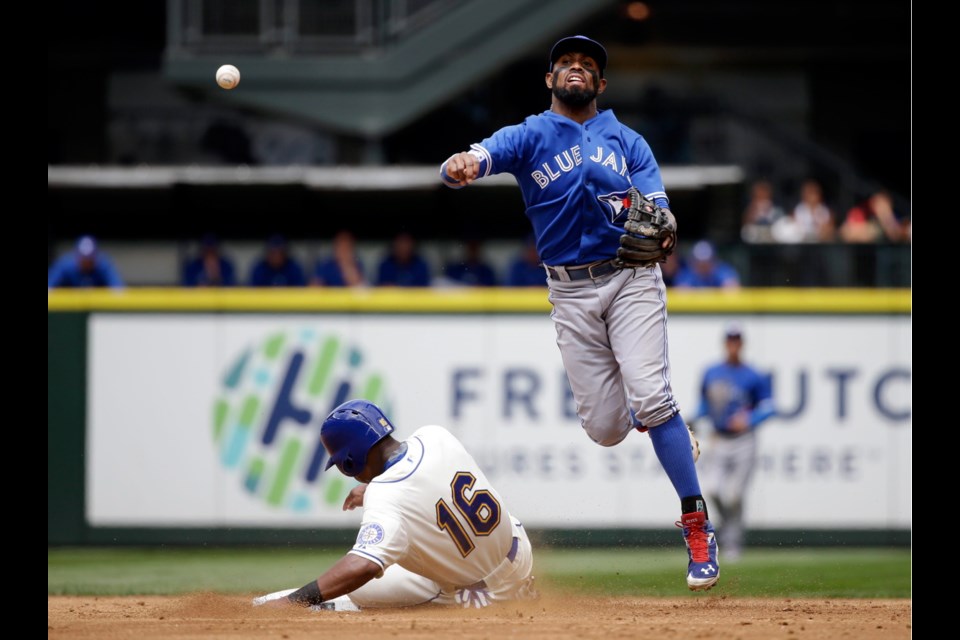 Toronto Blue Jays shortstop Jose Reyes, right, throws to first after forcing out Seattle Mariners' Austin Jackson (16) at second base on a double play in the third inning of Sunday's game in Seattle. Mariners' Kyle Seager was out at first on the play.