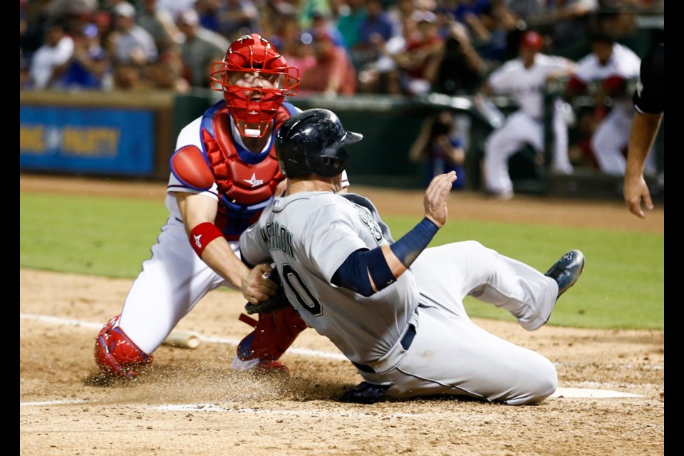 Texas Rangers catcher Bobby Wilson (8) tags out Seattle Mariners' Logan Morrison (20) during the sixth inning on Monday, Aug. 17, 2015, at Globe Life Park in Arlington, Texas.