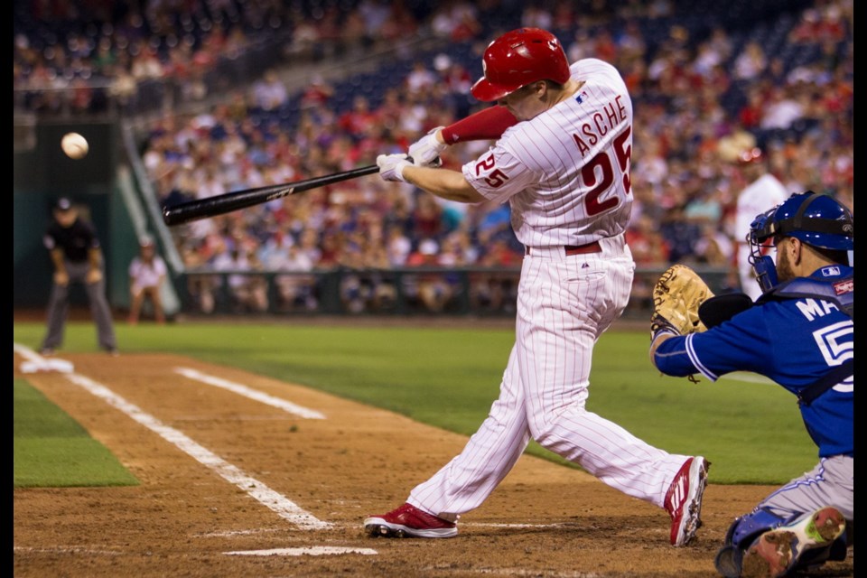 Philadelphia Phillies' Cody Asche (25) hits a single during the fourth inning of Tuesday's game against the Toronto Blue Jays, allowing Odubel Herrera to score in Philadelphia.