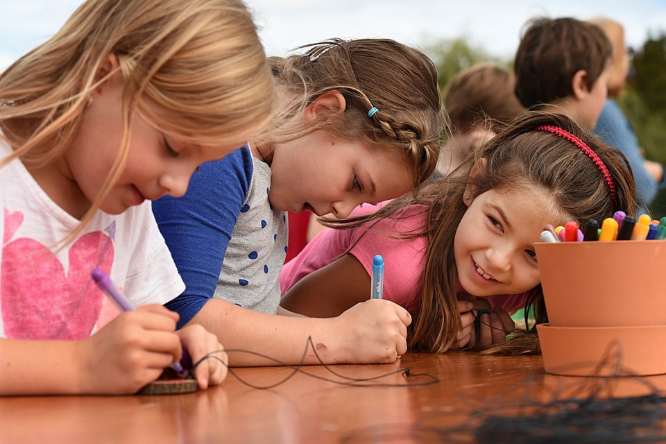 Grade 2 students at Dr. A.R. Lord elementary school, Lucy Alonso, Claire Mackie and Georgia Knight took part in National Tree Day last Wednesday, crafting wooden necklaces. photo Dan Toulgoet