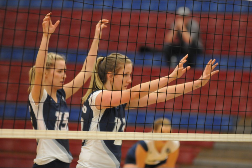 Capilano University volleyball players Sarah Hughes and Kolby Richter arm themselves for a rally during a strong run to a PacWest bronze medal last season. The two Blues are back this year and keen to lead the team a step or two higher up the podium.