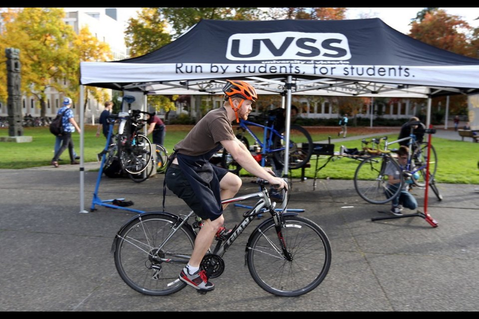 Kilian Loftis, president of the UVic Cycling Club, test-rides a repaired bike during the Sustainability Week event.