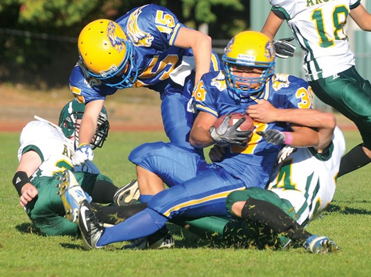 Argyle's no. 34 Trevor Yip (white) pulls down Handsworth's no. 38 Chris Moon during AA football game at Handsworth.