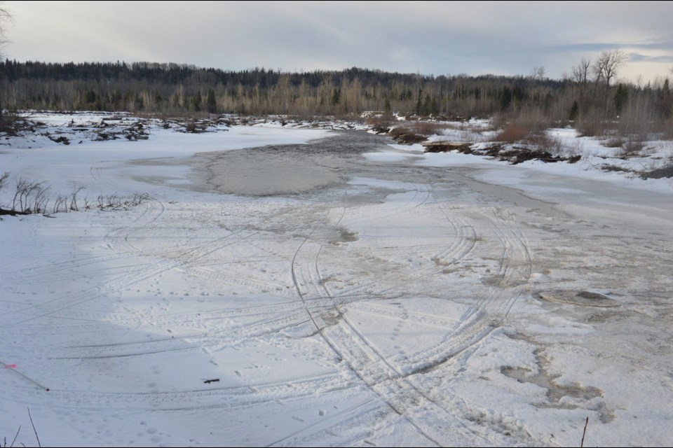 A snowmobiler is missing after he attempted to hydroplane across a section of open water, shown in this RCMP handout photo, on the Salmon River Monday evening. A person who tried to rescue him also remains missing.