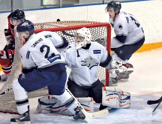 North Van Wolf Pack players #2 Jason Hawkins, goalie Braden Krogfoss and #18 Dylan Tuskey follow the puck behind the net in game against North Delta Devils at Harry Jerome Arena.