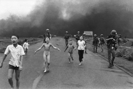 South Vietnamese forces follow after terrified children, including nine-year-old  Kim Phuc, centre-left, as they run down Route 1 near Trang Bang after an aerial napalm attack on suspected Viet Cong hiding places on June 8, 1972.  A South Vietnamese plane accidentally dropped its flaming napalm on South Vietnamese troops and civilians. The terrified girl had ripped off her burning clothes while fleeing. The children from left to right are: Phan Thanh Tam, younger brother of Kim Phuc, who lost an eye, Phan Thanh Phouc, youngest brother of Kim Phuc, Kim Phuc, and Kims cousins Ho Van Bon and Ho Thi Ting.