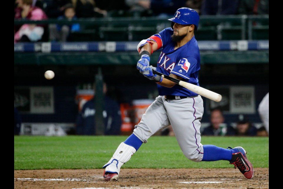 Texas Rangers' Rougned Odor hits a two-run single in the eighth inning of Monday's game against the Seattle Mariners in Seattle.