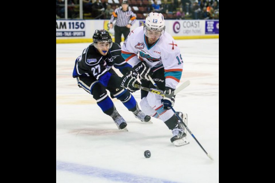 Rockets forward Dillon Dube tries to head up ice while being checked by Royals forward Jared Dmytriw during the first period at Prospera Place in Kelowna on Tuesday.