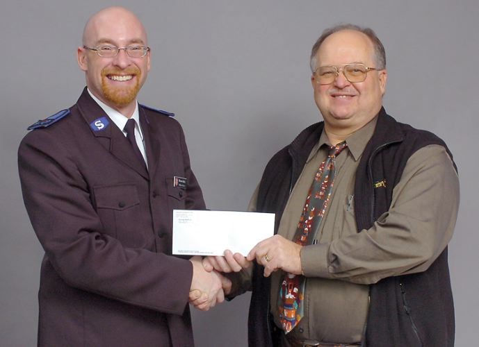 Sid Doucette, right, presented then-Salvation Army Envoy Bruce Kirk with $500 raised during the Doucette Realty Christmas Party raffle in December 2006.