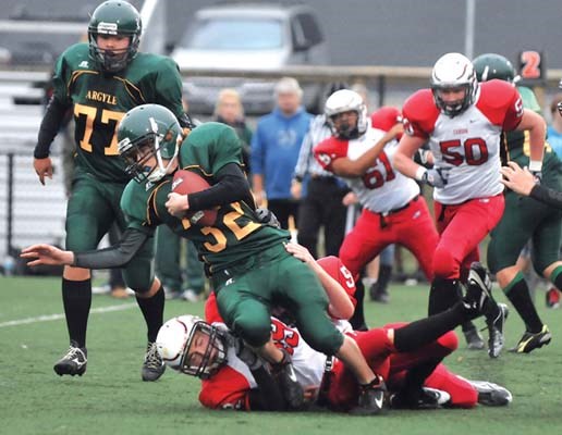 Argyle's #32 (green) Brian Simmons is taken down by Carson Graham's #49 Jeremy Sinclair in AA senior action at Carson.