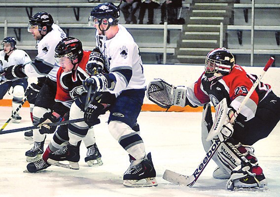 North Vancouver Wolf Pack no. 15 Garrett Woodside (white) in thick of action in Junior B playoff action against Richmond Sockeyes (red) at Harry Jerome Arena.