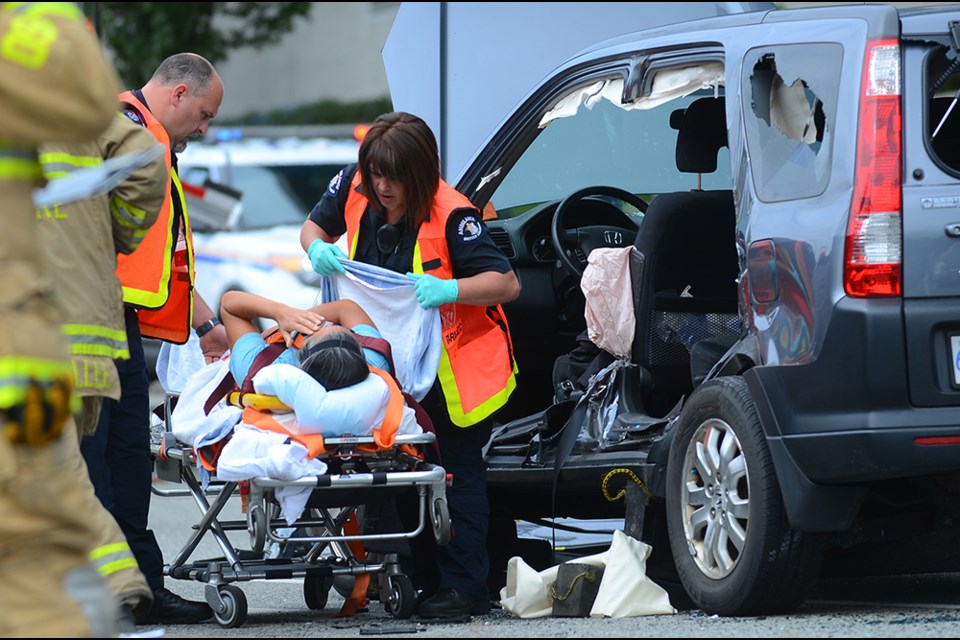 A woman extracted from her vehicle with the jaws of life is taken to hospital after a three-car crash on Lougheed Highway Wednesday.