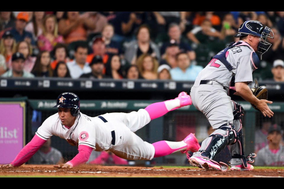 Houston Astros' George Springer, left, slides safely home past Seattle Mariners catcher Steve Clevenger on Carlos Correa's RBI-single in the seventh inning of Sunday's game in Houston.