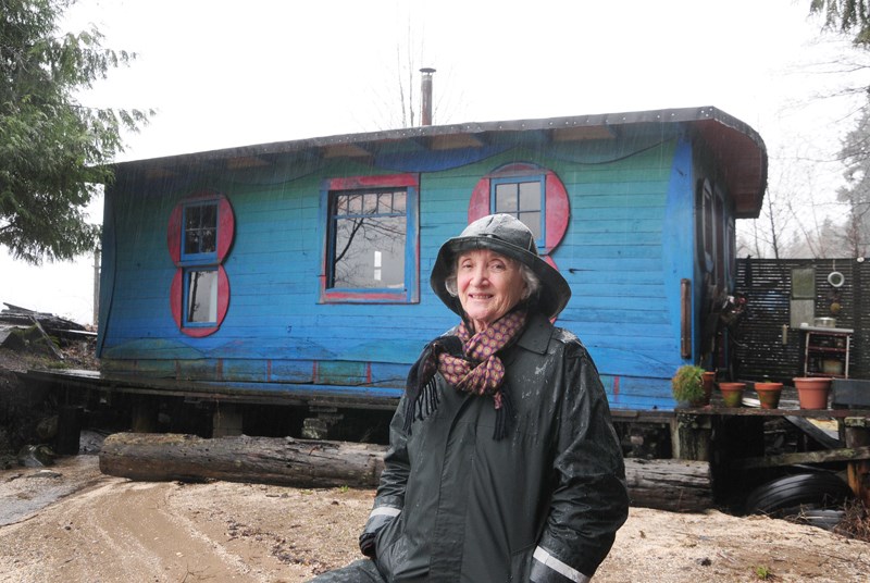 Artist Carole Itter in front of the Blue Cabin on the waterfront in 2015.