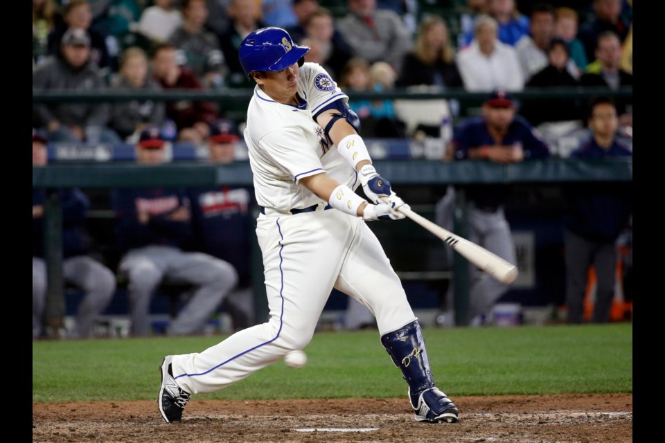 Seattle Mariners' Dae-Ho Lee swings and misses to strike out and end Sunday's baseball game against the Minnesota Twins in the ninth inning Sunday in Seattle.