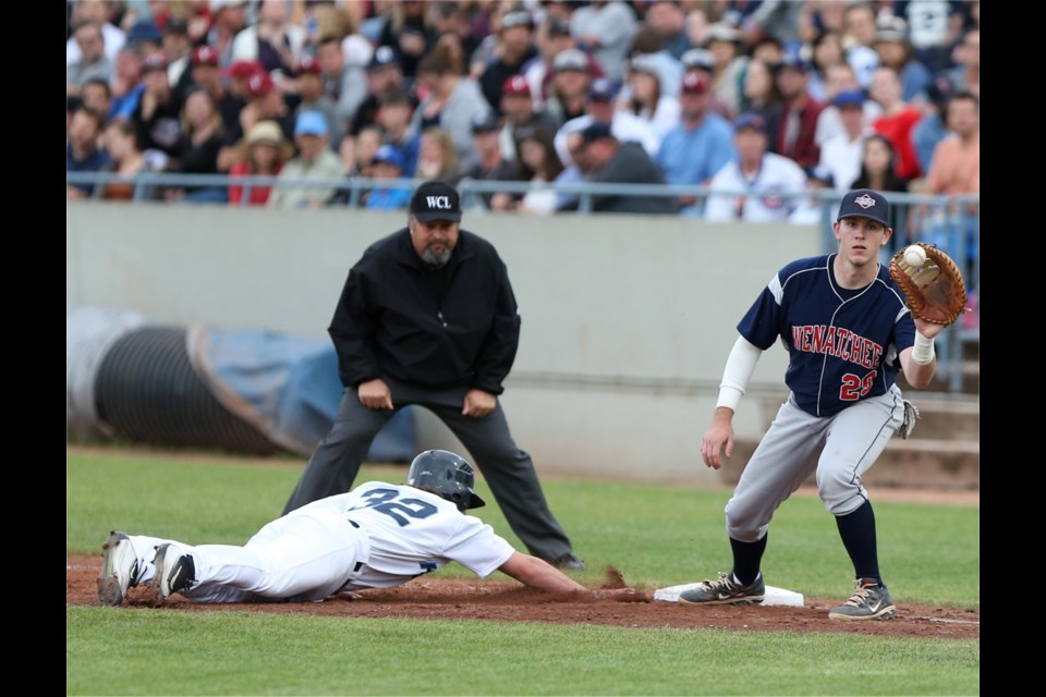 Victoria HarbourCats player Justin Brown makes it back to first base before Wenatchee AppleSox first baseman Steve Machtolf gets the ball.