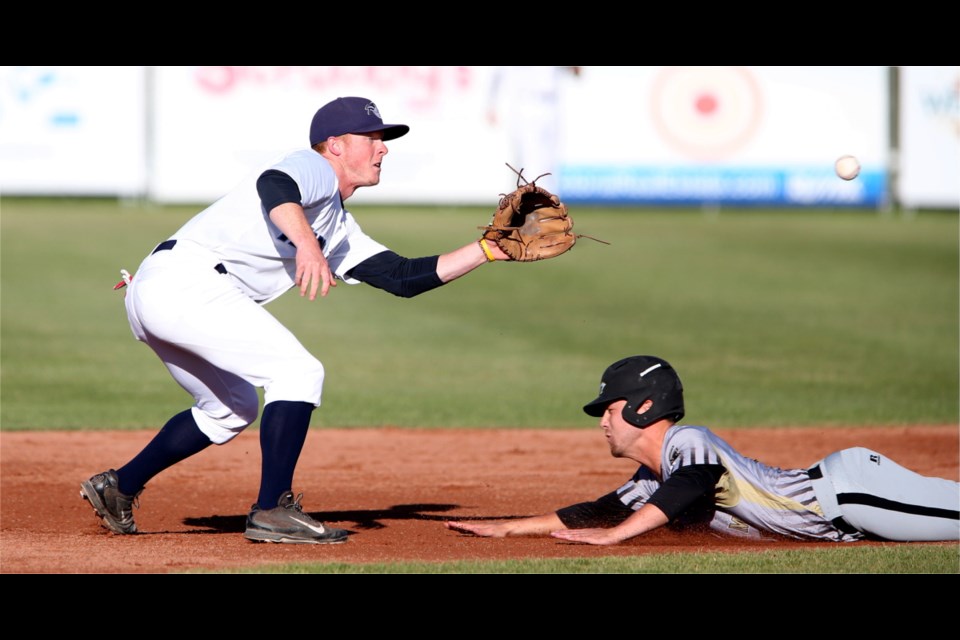 Gresham Greywolves Ryan Smith (13) slides into second base safely past Victoria HarbourCats Griffin Andreychuk (21) during Wednesday's game.