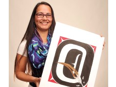 Jennifer Annaïs Pighin holds up her contribution of the letter Q to the Alphabet Project.