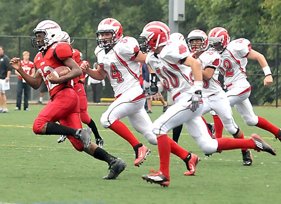 Carson Graham Eagles #22 Keishon Ross is pursued by a pack of John Barsby Bulldogs.