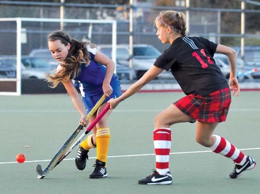 West Vancouver's #11 Justine Balen (black) and Handsworth's Meghan Norlander (blue) battle at Rutledge field for the North Shore junior field hockey title.