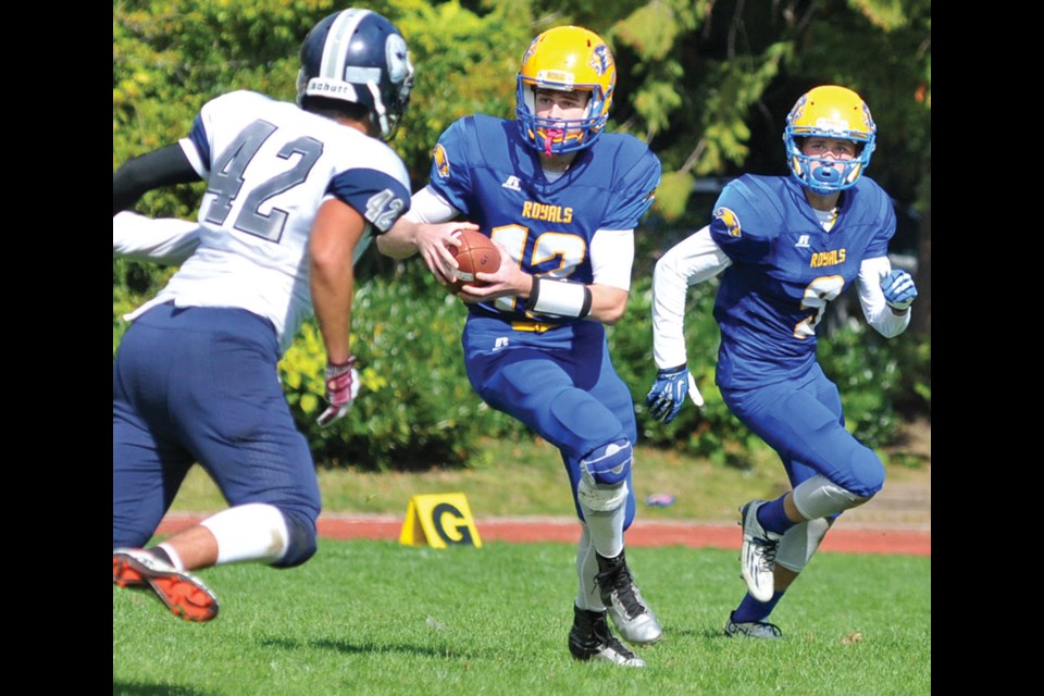 Handsworth quarterback Sam Tholl rolls out with receiver Dane Hopkins by his side during a 19-6 win over G.W. Graham Saturday. Next up for the Royals is the annual Buchanan Bowl grudge match at Carson Graham Saturday. photo by Paul McGrath, North Shore News